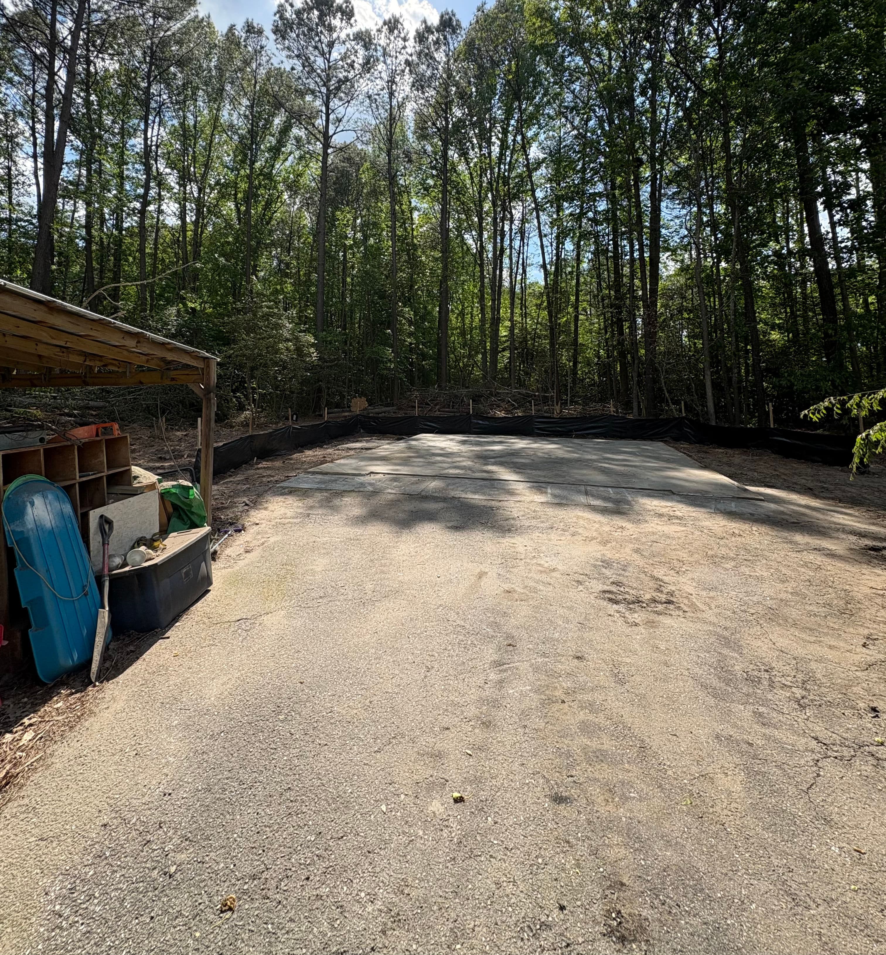 Cleared outdoor space surrounded by trees, ready for construction or landscaping projects.